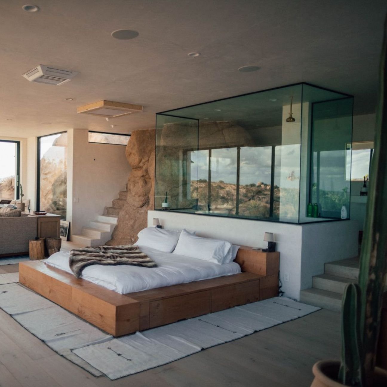 Modern luxury bedroom with wooden bed and glass shower in Prestige Siddharth Vihar Ghaziabad apartment